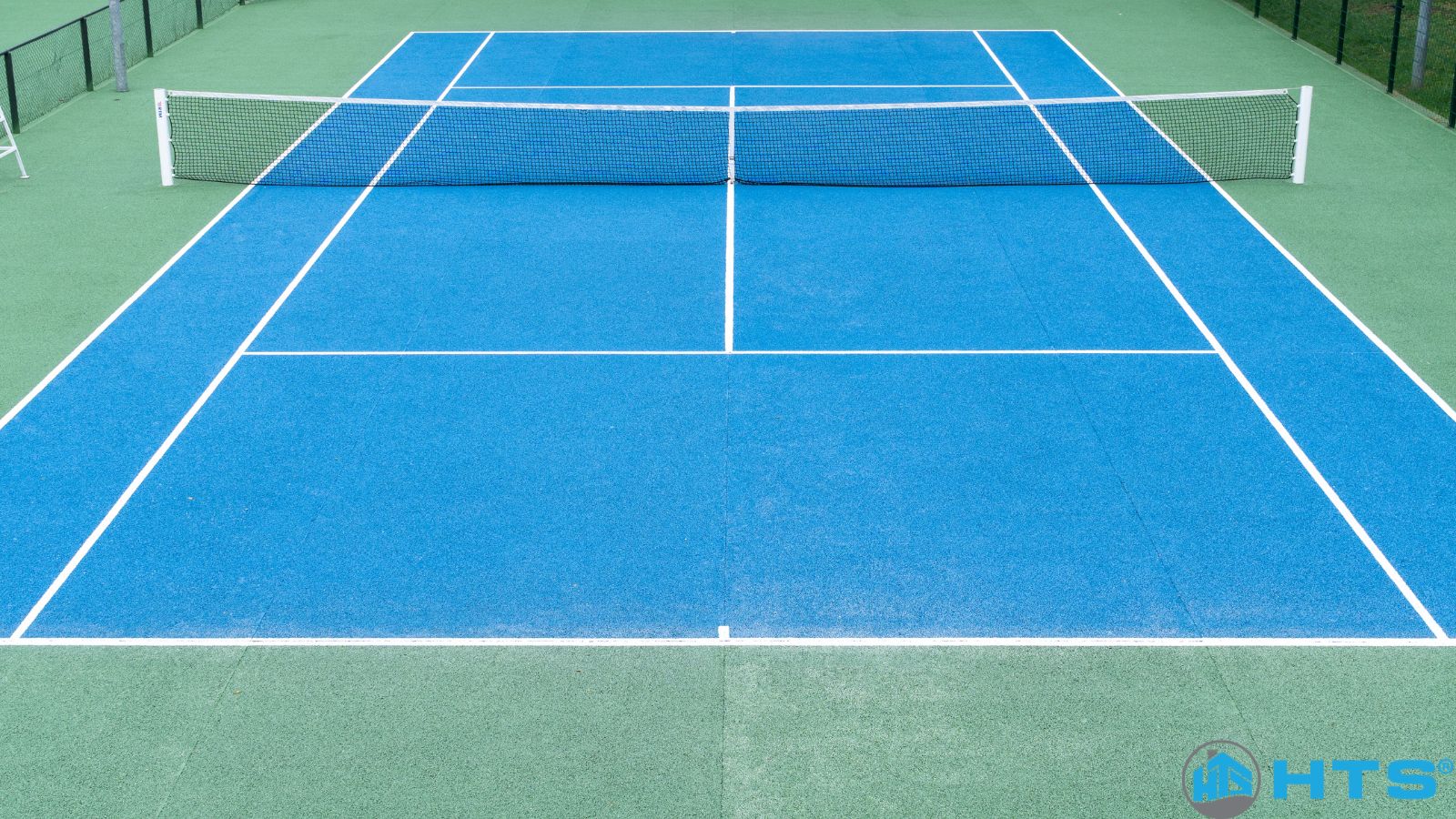 Hình ảnh sân tennis tiêu chuẩn với bề mặt cứng, lưới chắn bóng và hệ thống chiếu sáng, minh họa cho chi phí làm sân tennis